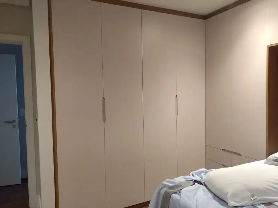 Quarto moderno com guarda-roupa espaçoso e cama com roupa de cama branca