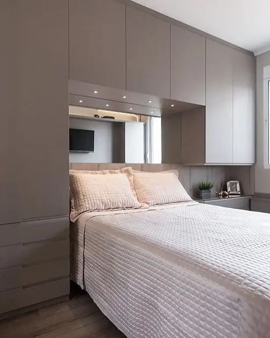 Quarto minimalista com cama branca e armários embutidos cinza