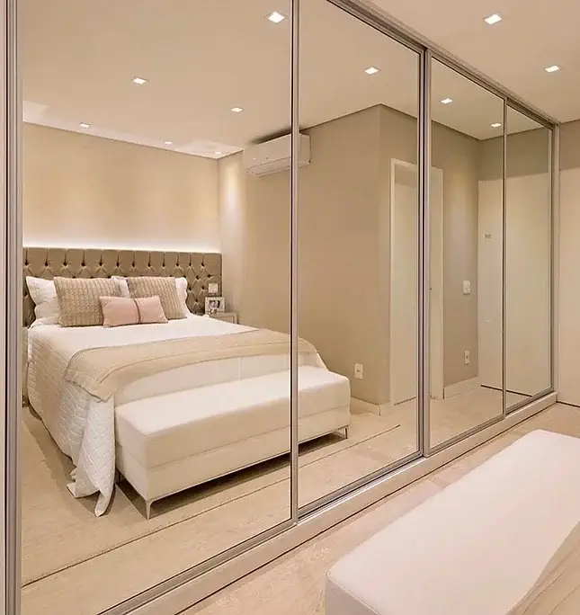 Quarto moderno com cama grande e portas de armário espelhadas