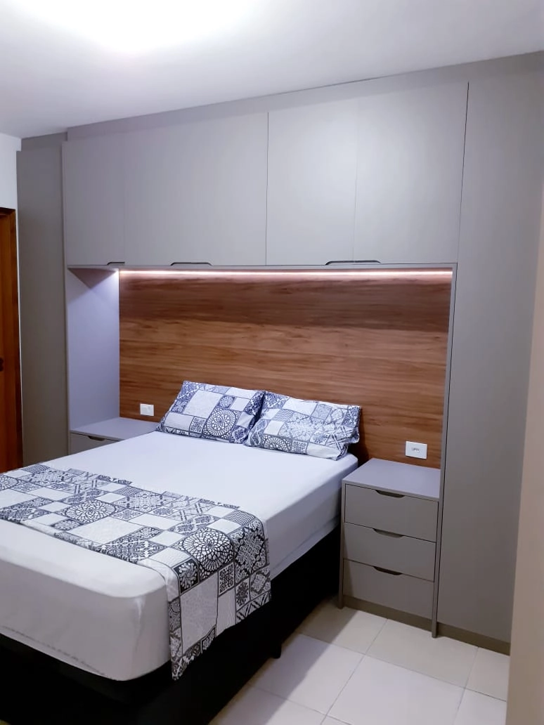 Quarto moderno com móveis planejados em tons de cinza e detalhes em madeira