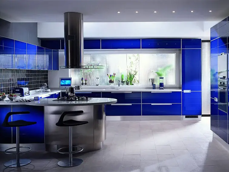 Cozinha moderna com tonalidade azul vibrante, bancada central e eletrodomésticos de inox.